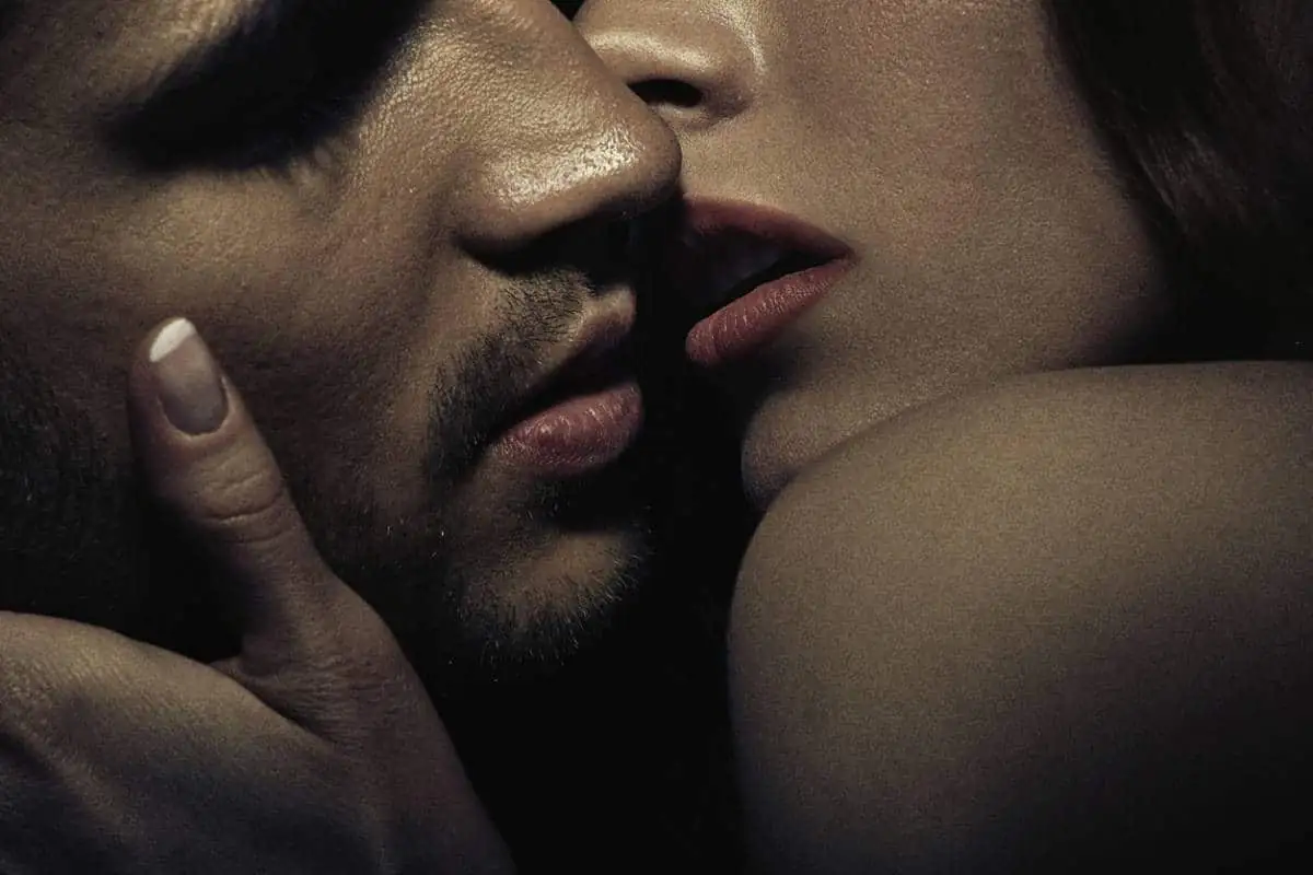 Gros plan sur un couple, la main d'une femme sur la joue d'un homme, visages presque joints
